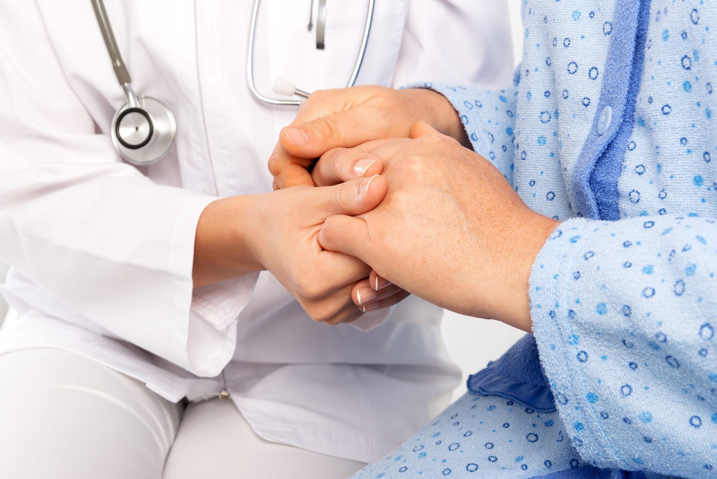 medical personnel holding a patient's hands