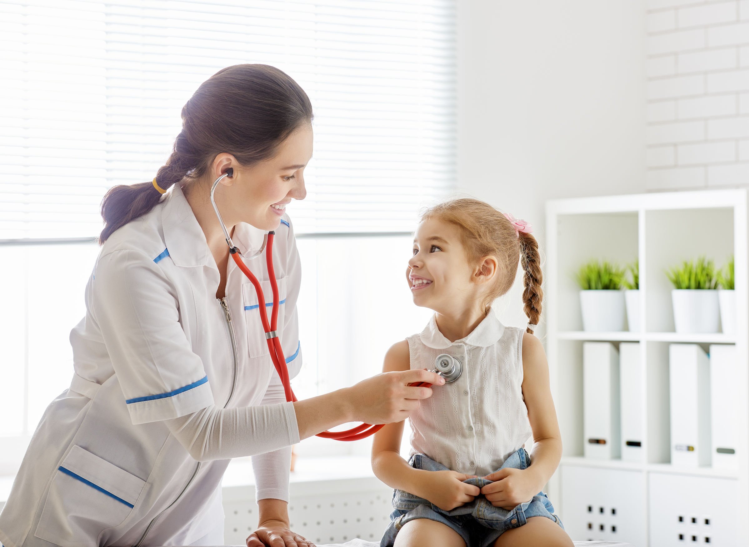 Doctor listening to the heartbeat of a small child