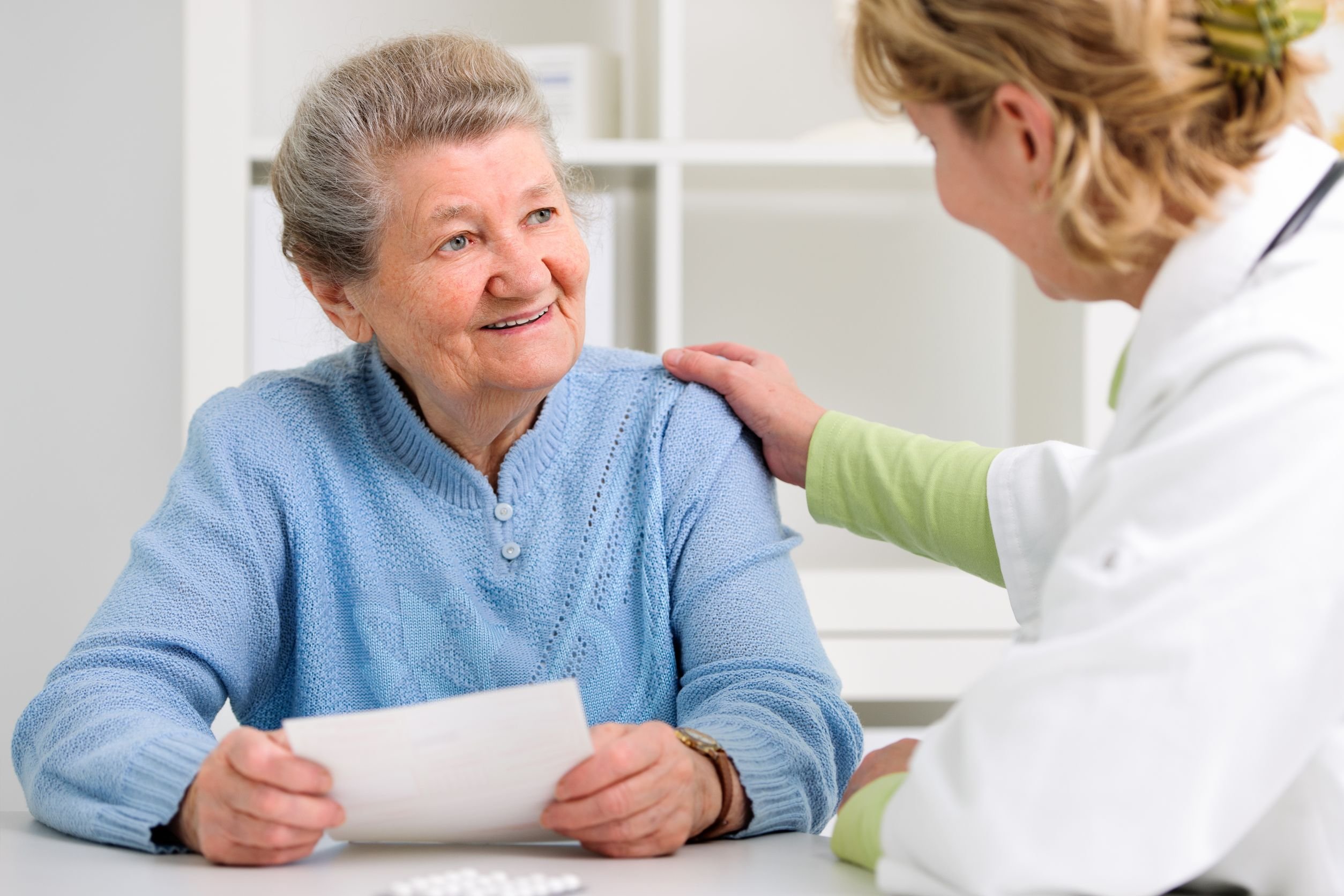 Older woman comforted by medical staff