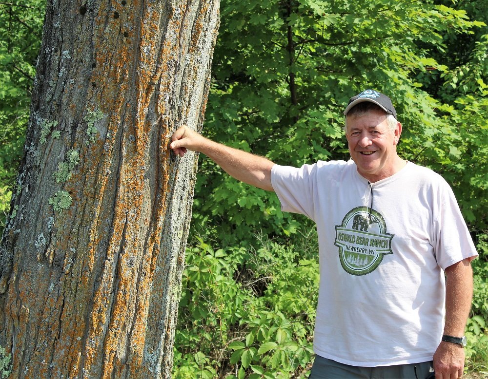 Jack Hubbard standing next to a tree